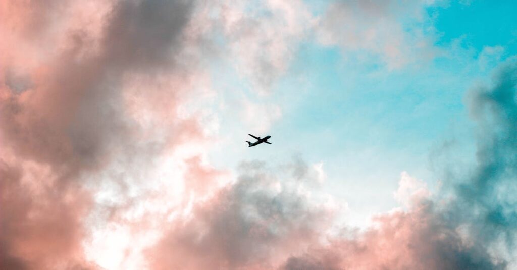 A plane flying through a colorful sky with pink and blue clouds, capturing the essence of travel.