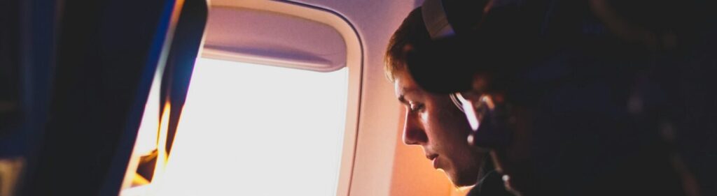 Someone distracted on a plane to show the distraction techniques to make the flight feel shorter.